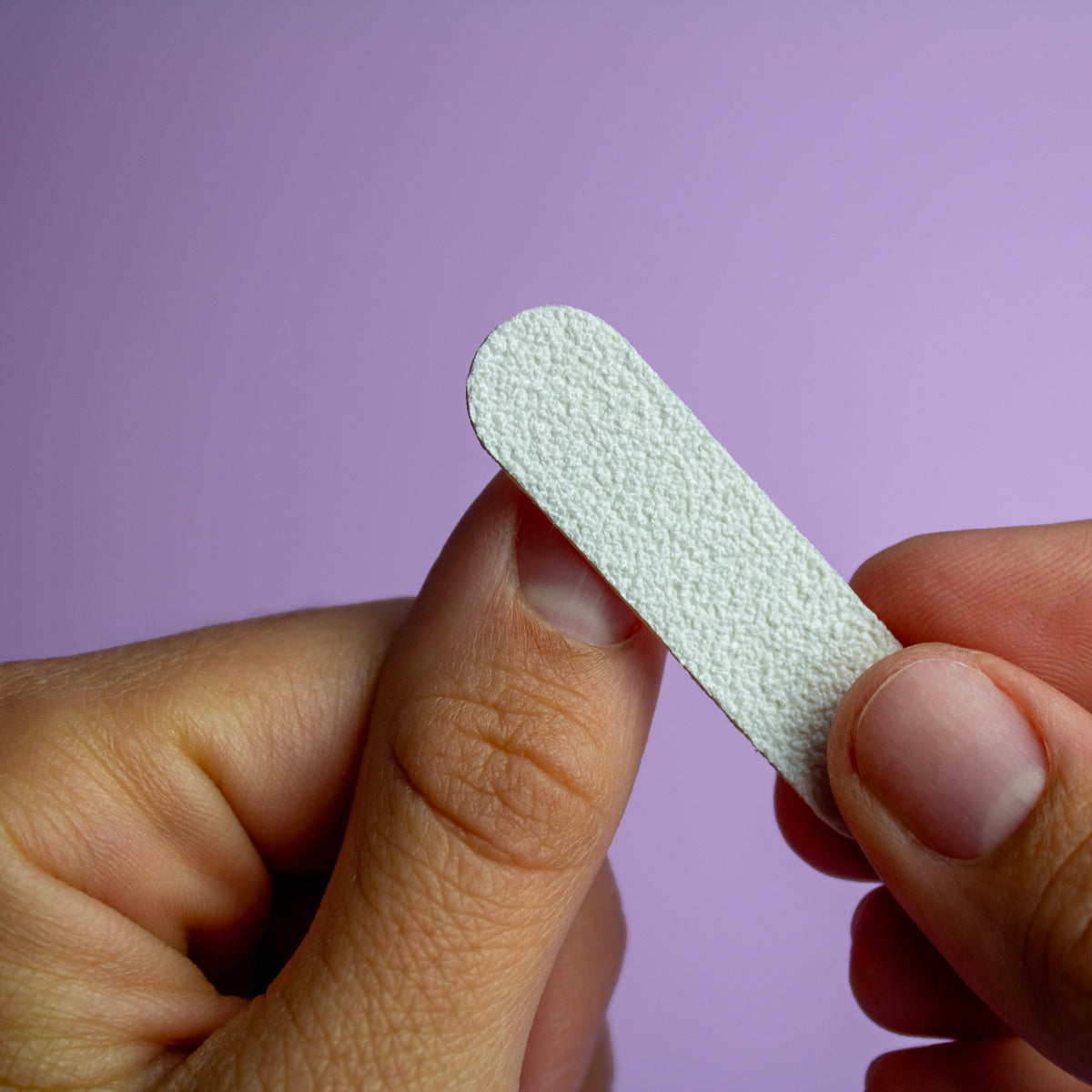 Appliceringsguide för lösnaglar med pre-applied glue tabs. Rugga upp nagelytan med nagelfilen.